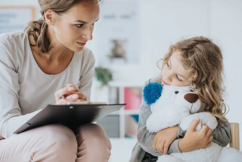 Profesional conversando con una niña en un espacio de atención.